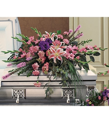 Pink and purple floral spray on a silver casket