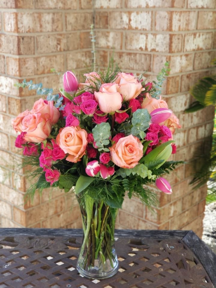 Pink and peach rose bouquet in a clear glass vase