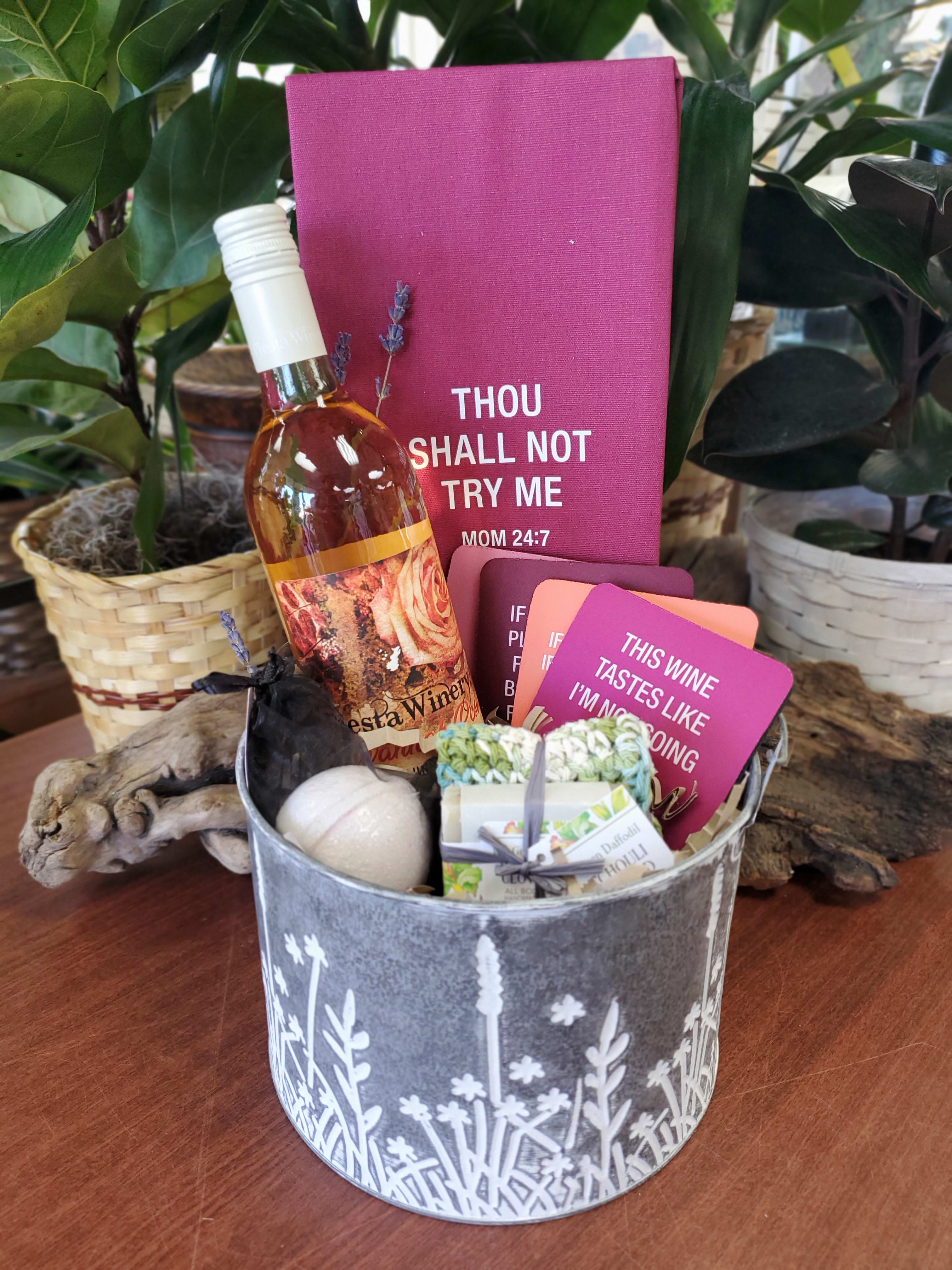 Gift basket with a wine bottle, cards, and small bath items