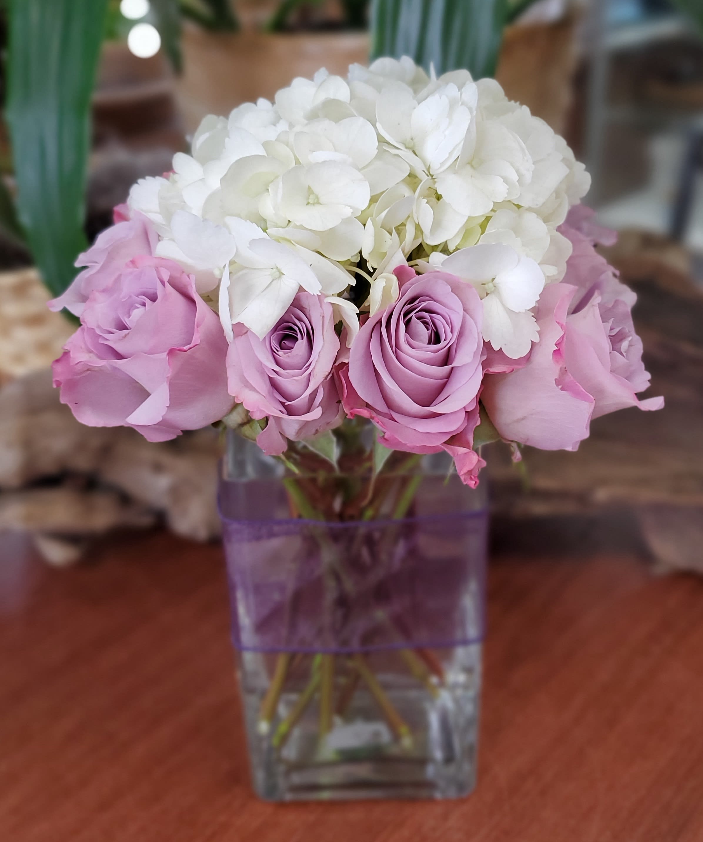 Pink roses and white hydrangeas in a clear square vase