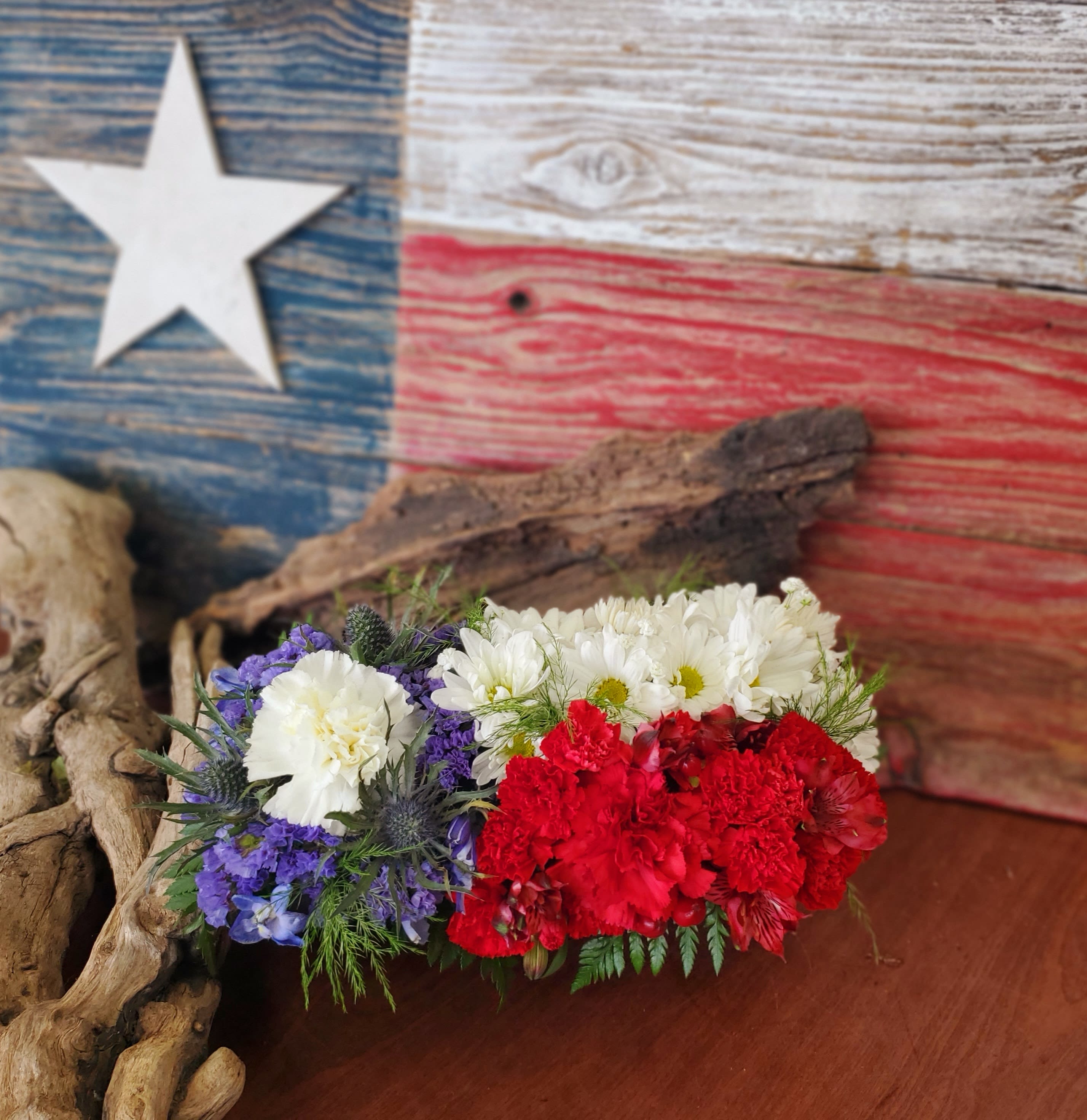 Red, white, and blue floral arrangement with carnations and daisies