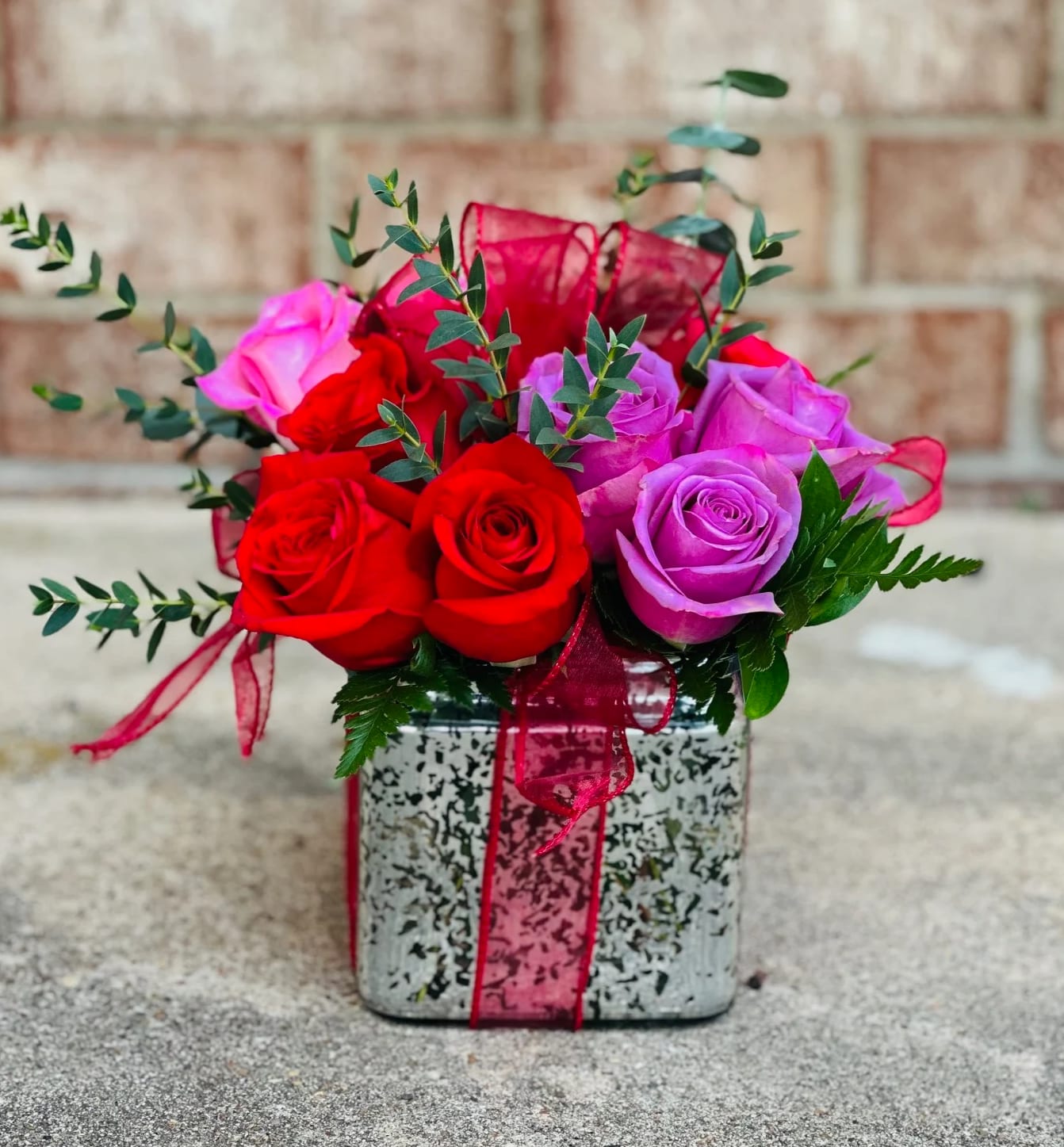 Bouquet of red and purple roses in a square decorative box
