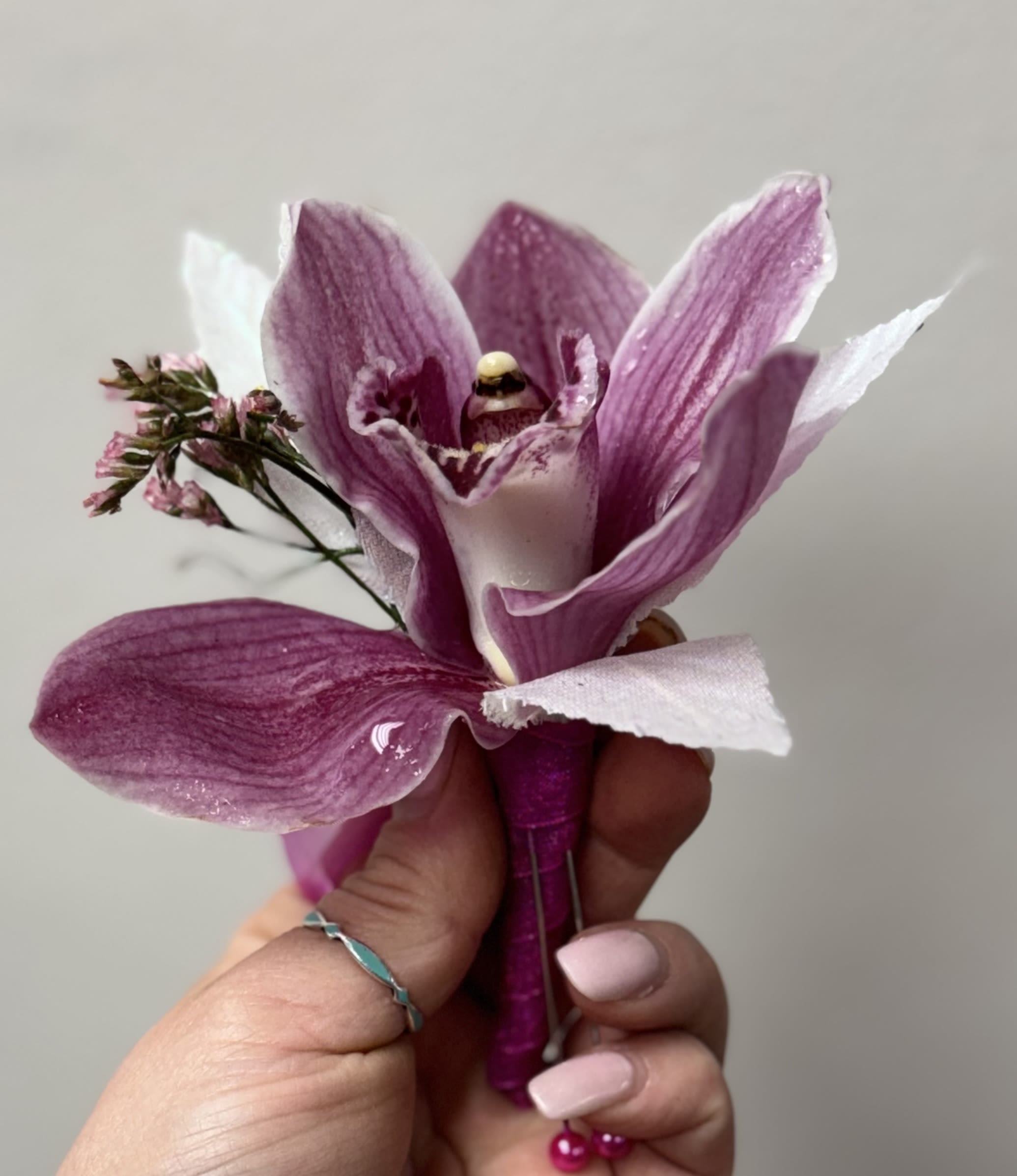 Purple orchid corsage held in a hand