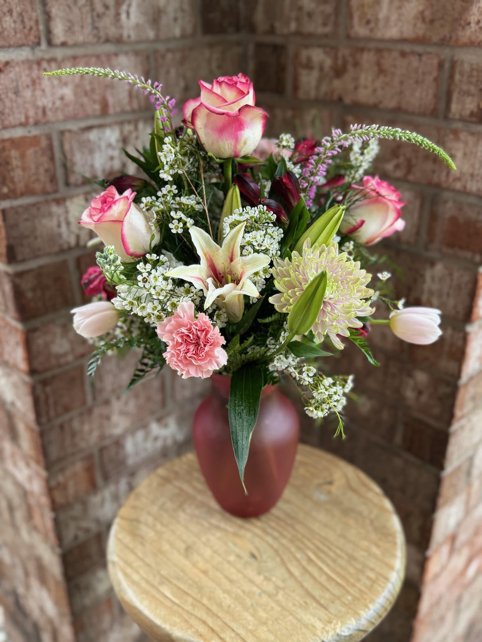 Pink and white bouquet in a red vase