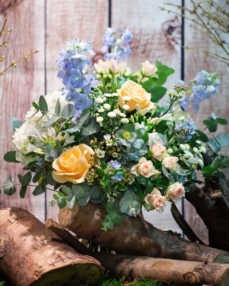 Bouquet of pale yellow roses and blue flowers with eucalyptus