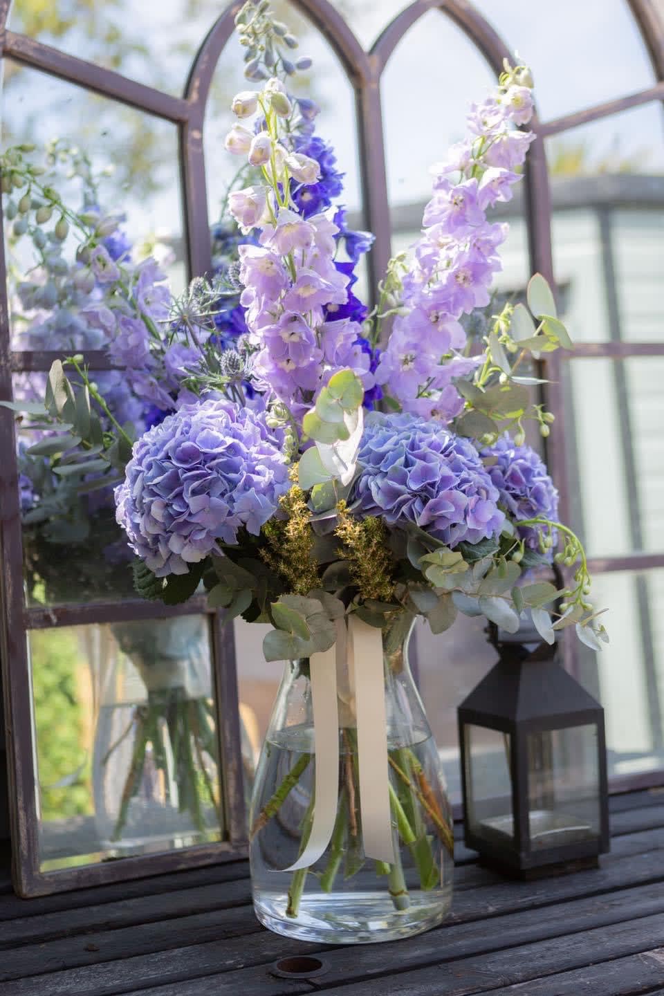 Lavender and blue floral arrangement in a clear glass vase