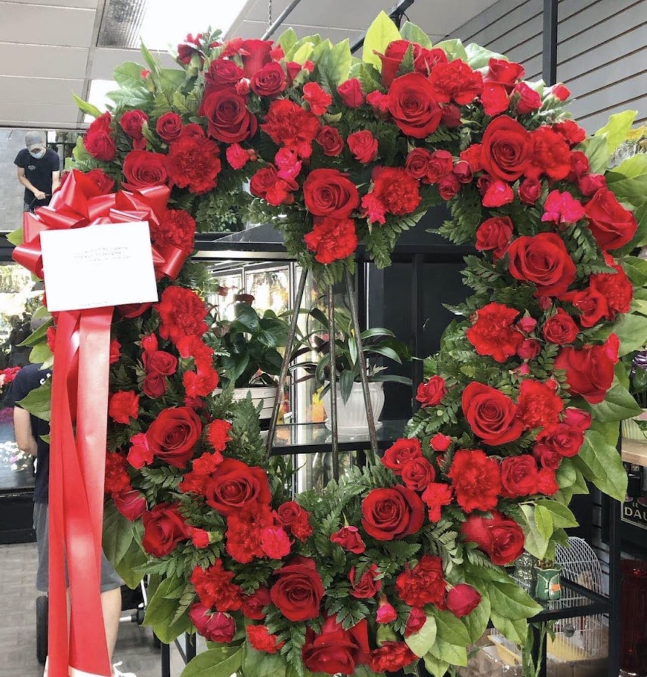 Love in our Hearts  - An all red tribute, this heart shaped easel shows your everlasting love. Featuring a variety of white flowers and greenery, this heart with a trail of ivy compliments the beauty of life. 