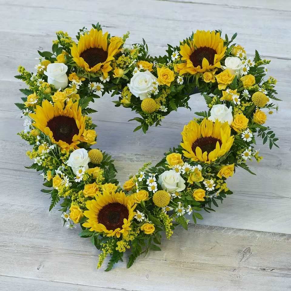Striking Sunflower Heart - A bright mix of striking sunflowers, mini roses and fillers in an open heart design.  Product Dimensions: Length: 44cm, Width: 48cm, Height: 12cm.