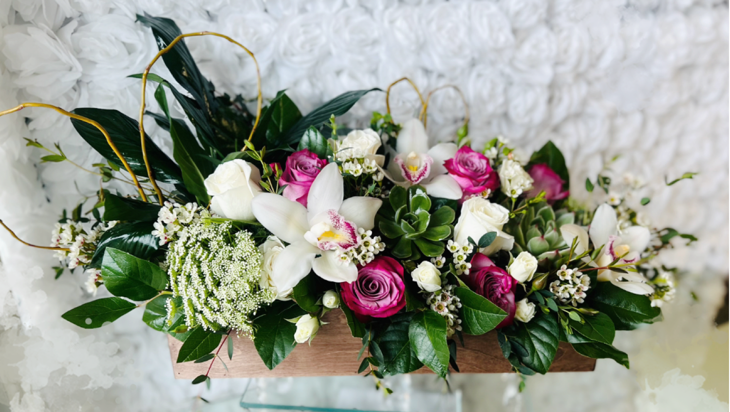Pink and white roses with white orchids in a wooden box