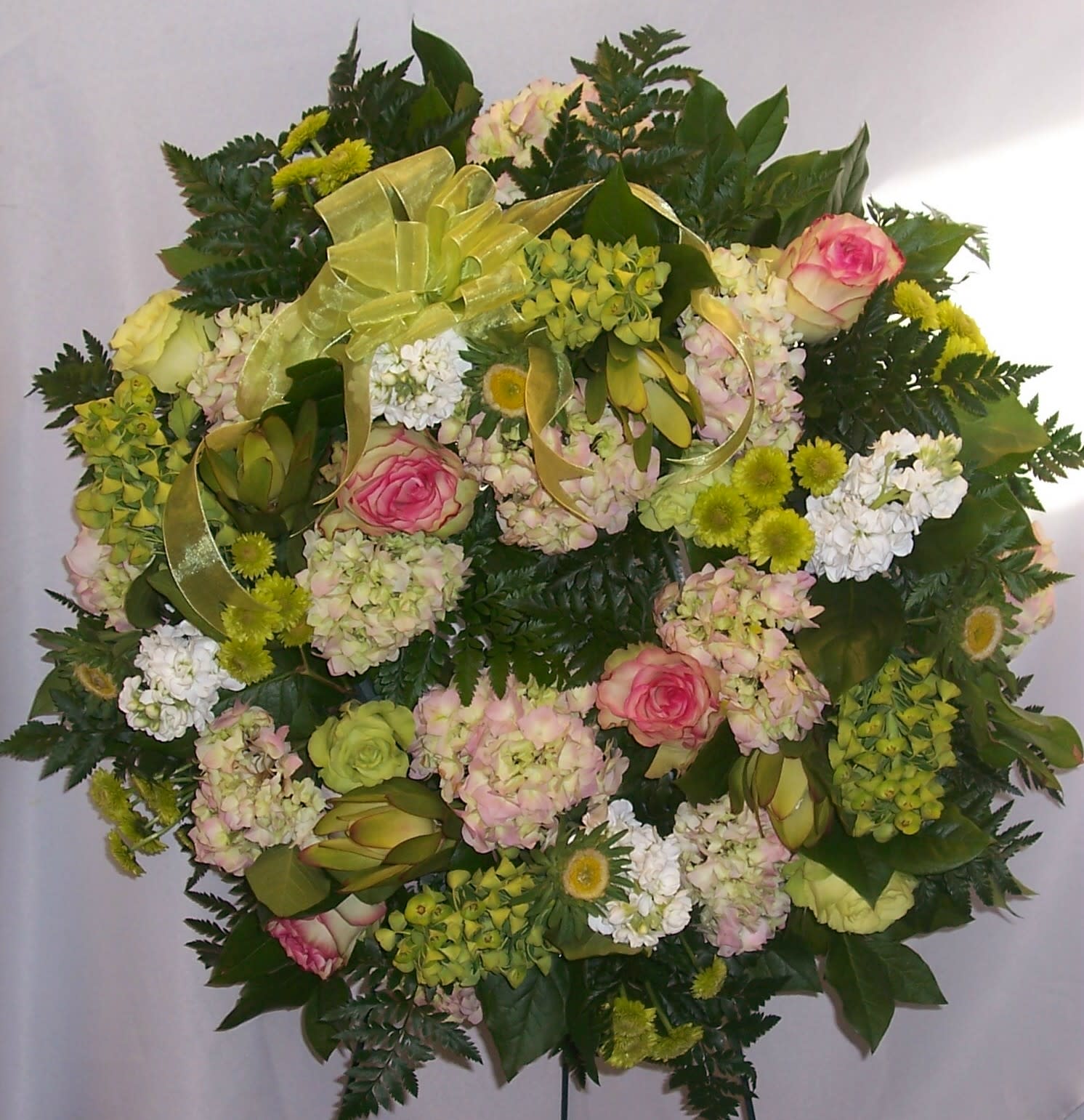 Round floral spray with pink roses, pale hydrangeas, and white blooms