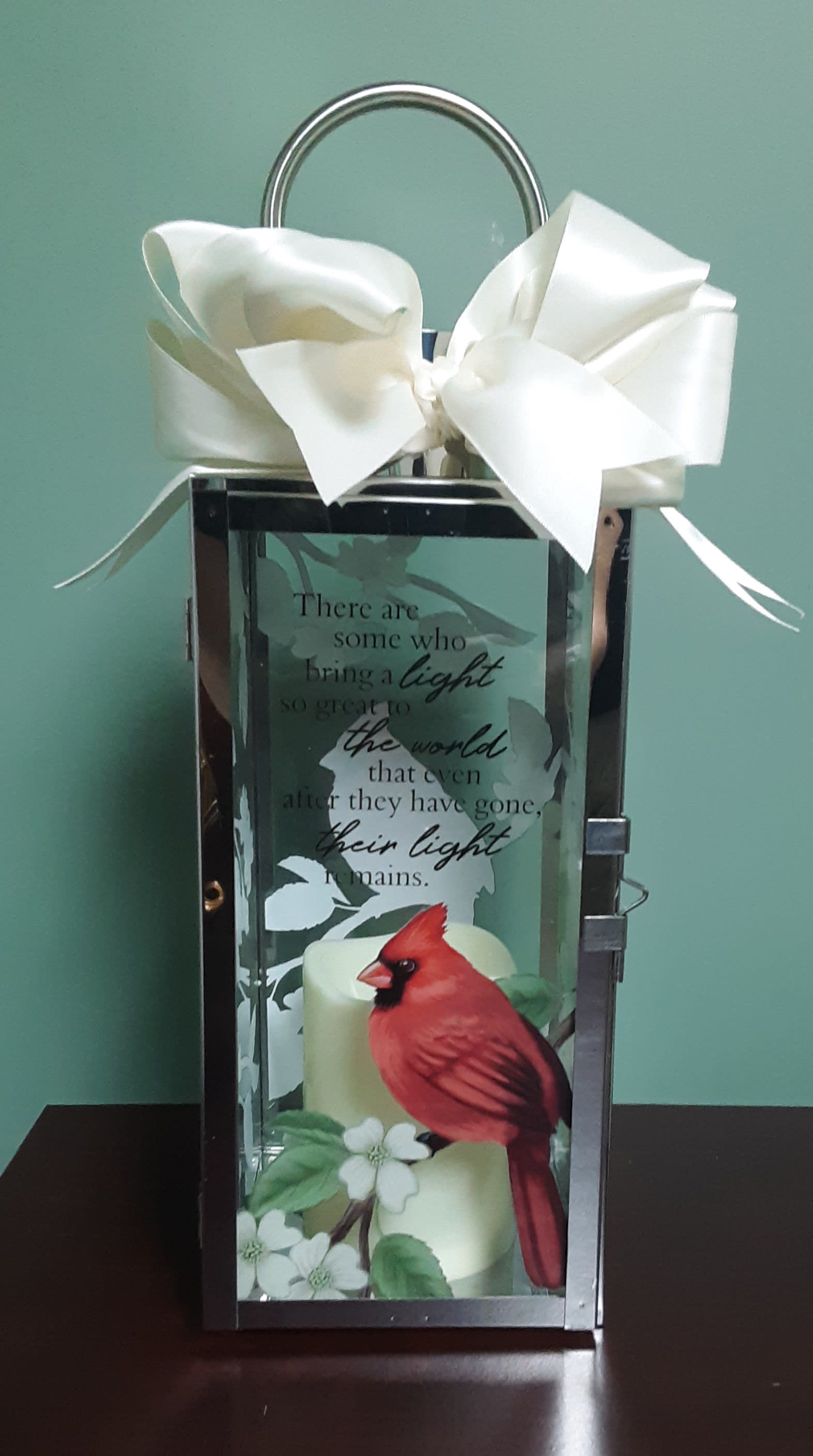 Decorative lantern with a white bow and cardinal design