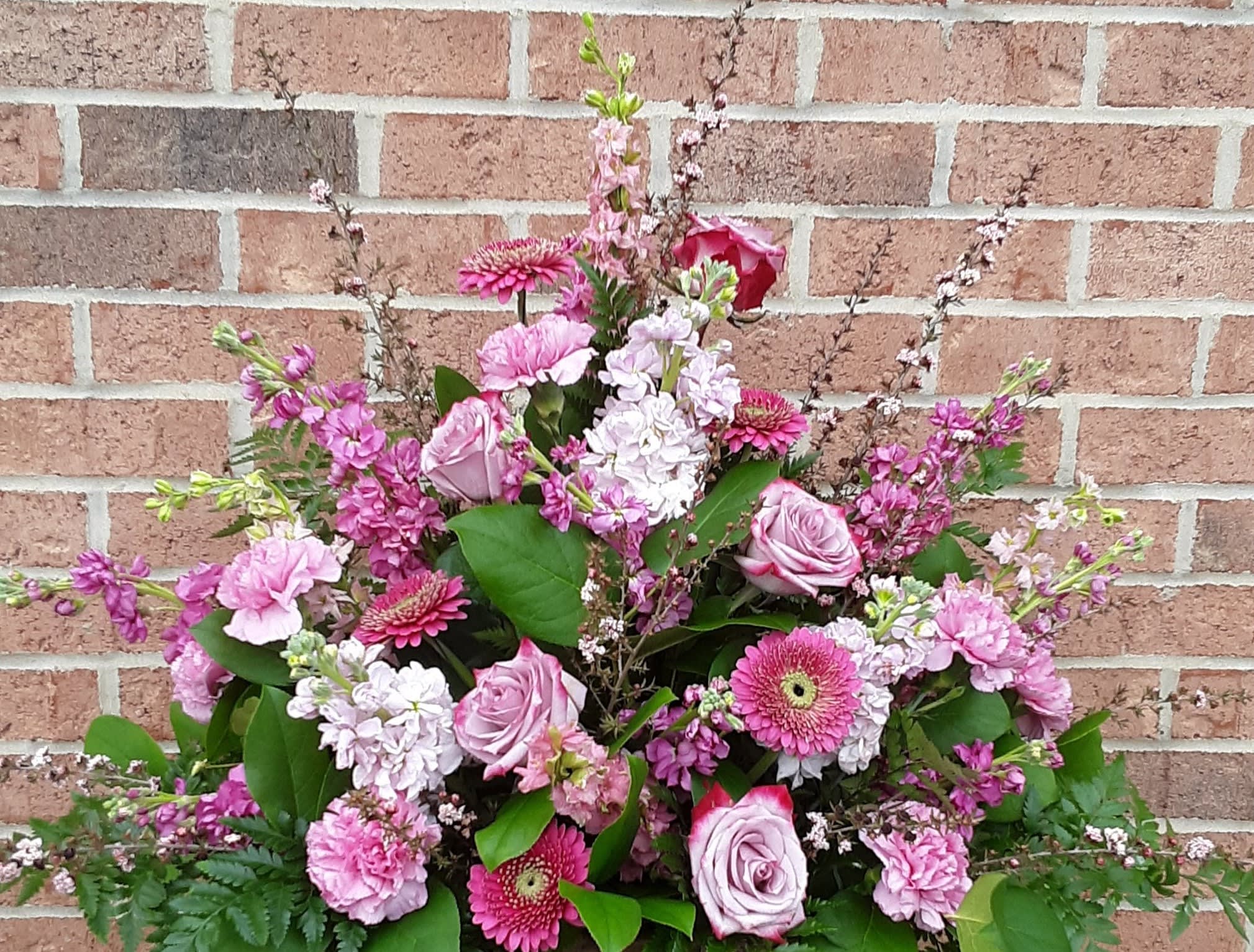 Large pink floral arrangement with roses, gerbera daisies, and carnations