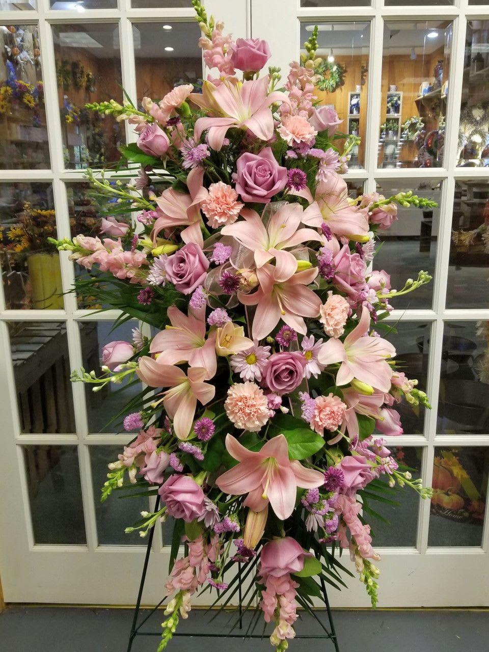 Tall pink floral standing spray with lilies, roses, and carnations