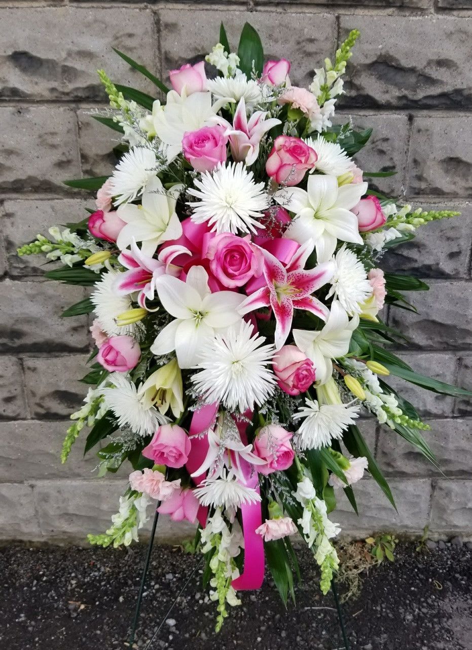 Standing floral spray with pink roses, white lilies, and white daisy-like blooms