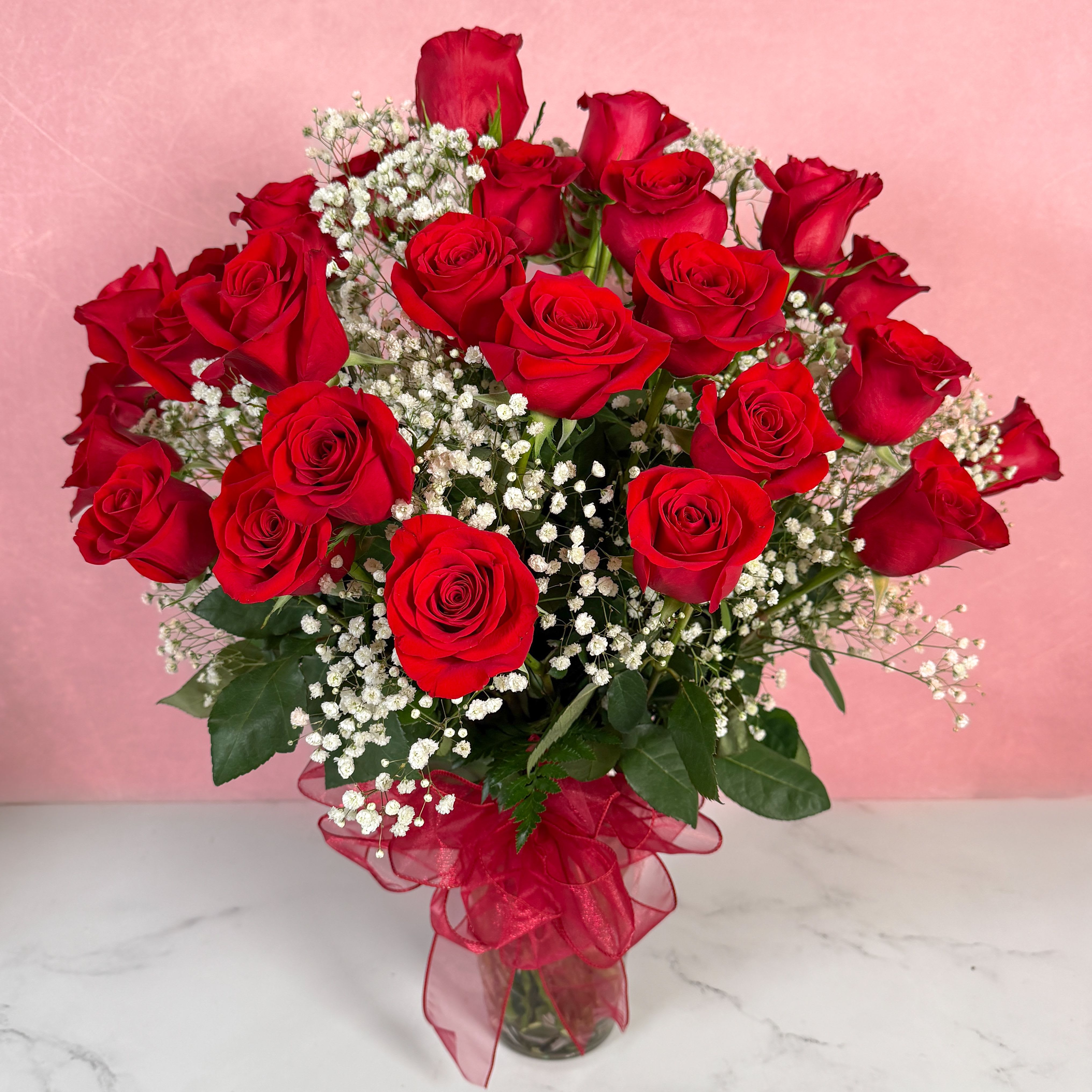 Bouquet of red roses with white baby's breath in a glass vase