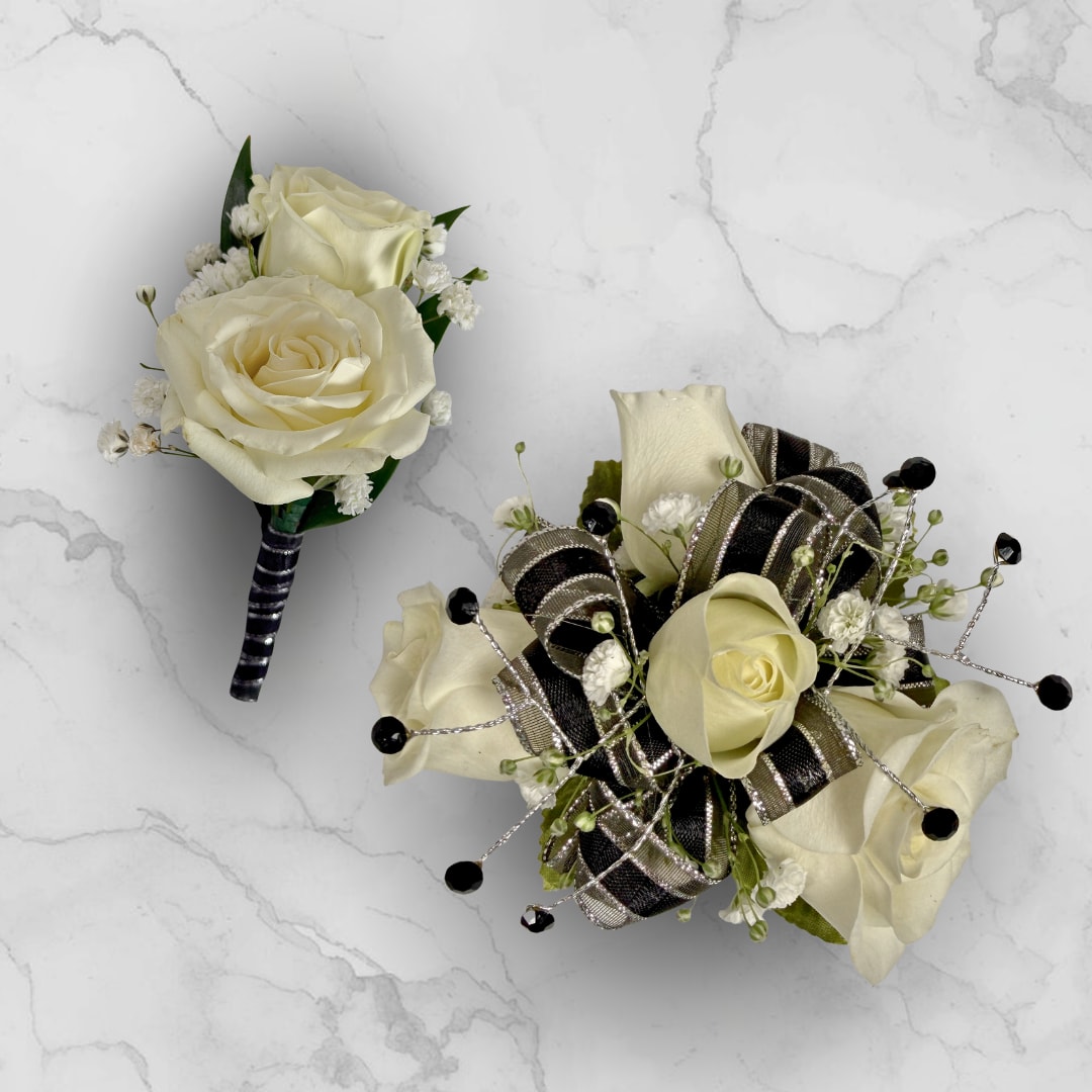 Onyx 4 Rose Combo - Make ordering prom flowers a breeze this year with our Onyx 4 Rose Combo! This combo comes with our Onyx Boutonniere - With Wrap and our Onyx 4 Rose Corsage, perfectly matched together to make a stunning, coordinating look.  The Onyx 4 Rose Corsage has four petite cream-white spray roses, nestled among tiny white filler blossoms for soft texture and a fresh, natural look. Black and silver ribbon loops and decorative gem-like rhinestones create an artful, tailored finish, all held together on a white lace wristlet for easy wearing.  The Onyx Boutonniere - With Wrap features two cream-white spray roses with small white baby's breath filler wrapped in a shimmering black and silver ribbon, with boutonniere pin to hold the piece in place throughout a night of fun and dancing.