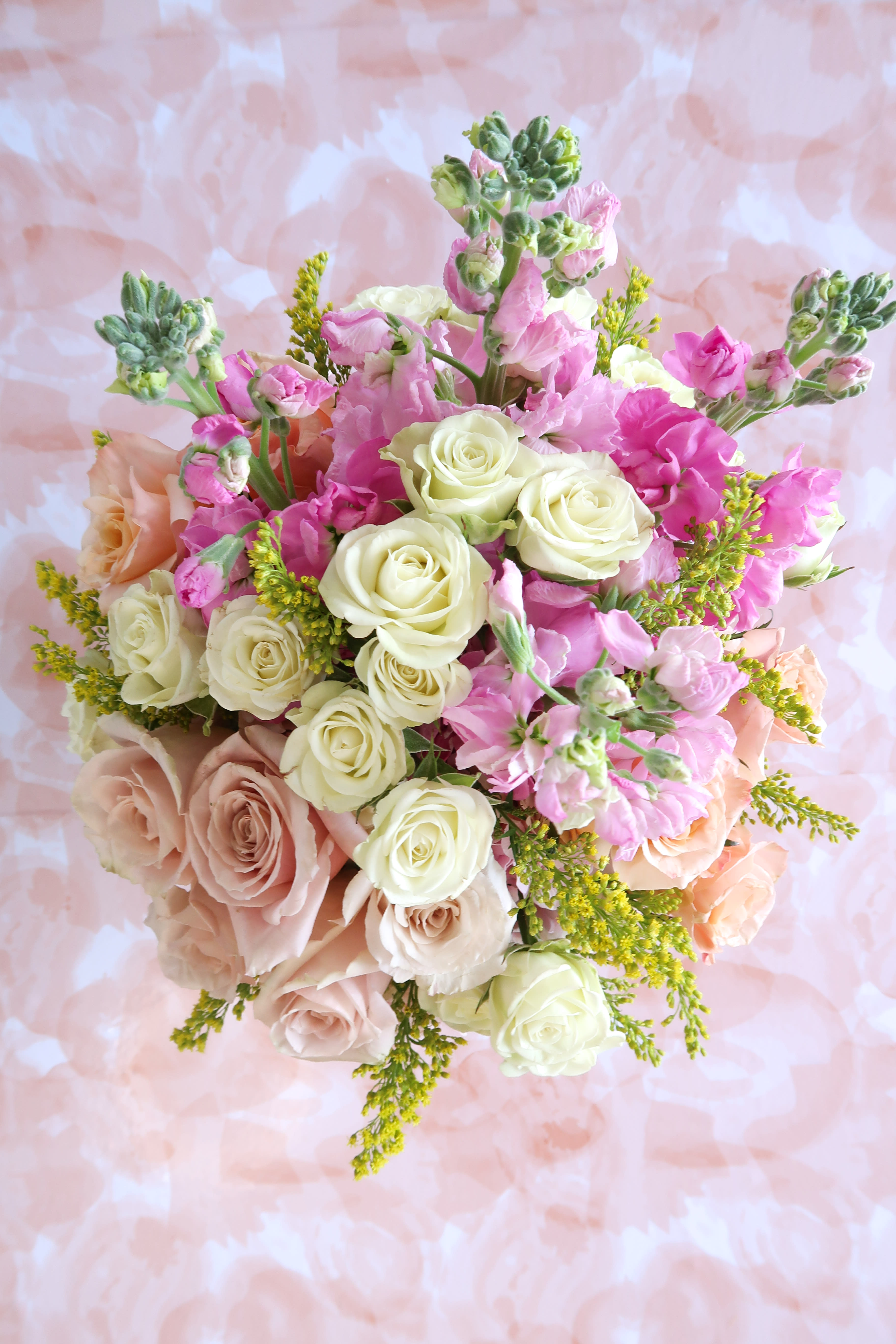 Bouquet of pink and cream roses with small pink blooms