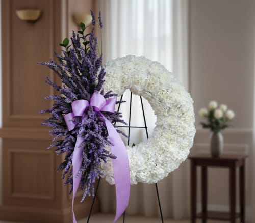 Graceful Remembrance Wreath - Graceful Remembrance Wreath – Sympathy Flowers in Tumwater, WA  Honor a loved one with the Graceful Remembrance Wreath, a timeless and heartfelt tribute for funerals or celebration of life services in Tumwater, WA. This elegant standing wreath features classic white carnations, a traditional symbol of remembrance, paired with seasonal lavender blooms to convey peace, serenity, and thoughtful sympathy.  Perfect for display at churches or funeral homes, the wreath can be delivered to local venues including Mills &amp; Mills Funeral Home in Tumwater, Funeral Alternatives in Tumwater and Lacey, and Woodlawn Funeral Home in Lacey, WA.  Please note: lavender is seasonal. If unavailable, Specialty Floral Design will provide a carefully selected substitution with similar lavender-hued flowers to maintain the wreath’s beauty and meaning.  As your local florist in Olympia, WA, Specialty Floral Design provides same-day flower delivery in Tumwater, Lacey, Olympia, and surrounding areas, offering compassionate, professional service when it matters most. The Graceful Remembrance Wreath is a meaningful way to express love, honor, and remembrance with flowers crafted with care.