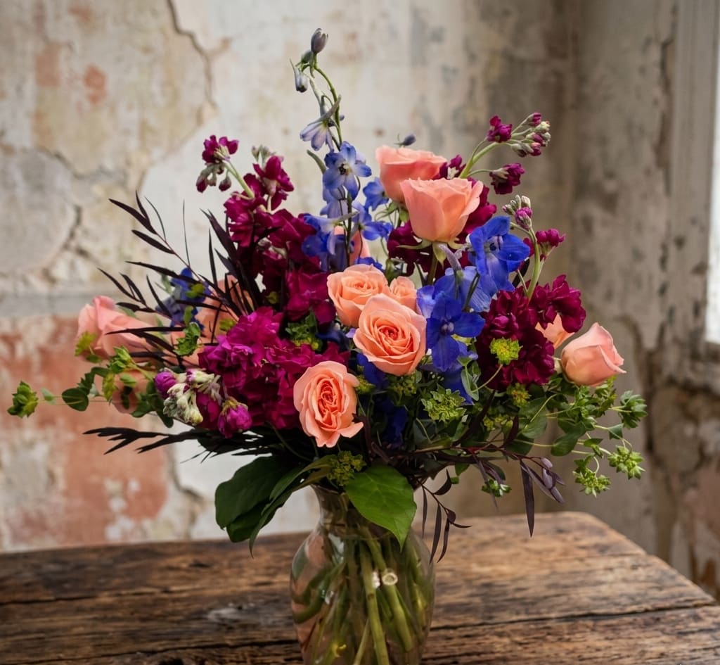 Oly Flowers - Oly Flowers – Flower Delivery in Olympia, WA  Looking for something bright, fun, and a little different? Oly Flowers is one of our favorite designs here at Specialty Floral Design in Olympia, WA. With bold hot pink and blue tones, this arrangement has a playful, eye-catching style that instantly lifts the mood.  We design this bouquet using seasonal flowers, so it may change throughout the year—but the overall look stays vibrant, colorful, and full of personality. It’s a great choice for birthdays, celebrations, or those moments when you just want to surprise someone with something beautiful.  Each arrangement is made right here in our shop, with a focus on color, texture, and that “wow” factor when it arrives. No two are exactly the same, which is part of what makes it special.  We offer same-day flower delivery in Olympia, Tumwater, Lacey, and nearby areas, so it’s easy to send flowers when it matters most. If you’re searching for a local florist in Olympia or reliable flower delivery, we’re here to help.  Order Oly Flowers today and send something fun, fresh, and full of life.  