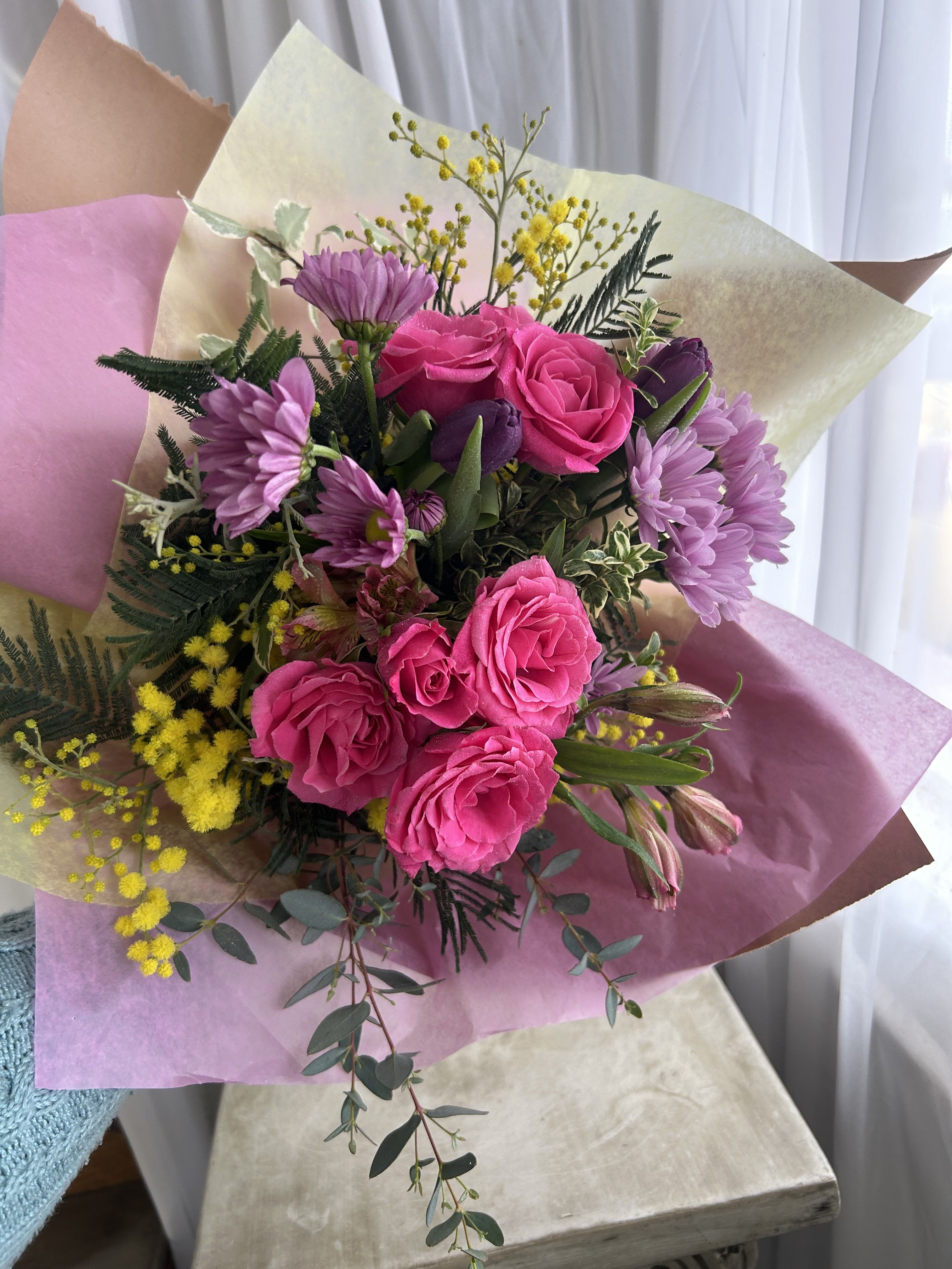 Bouquet of pink roses and purple daisies with yellow filler flowers