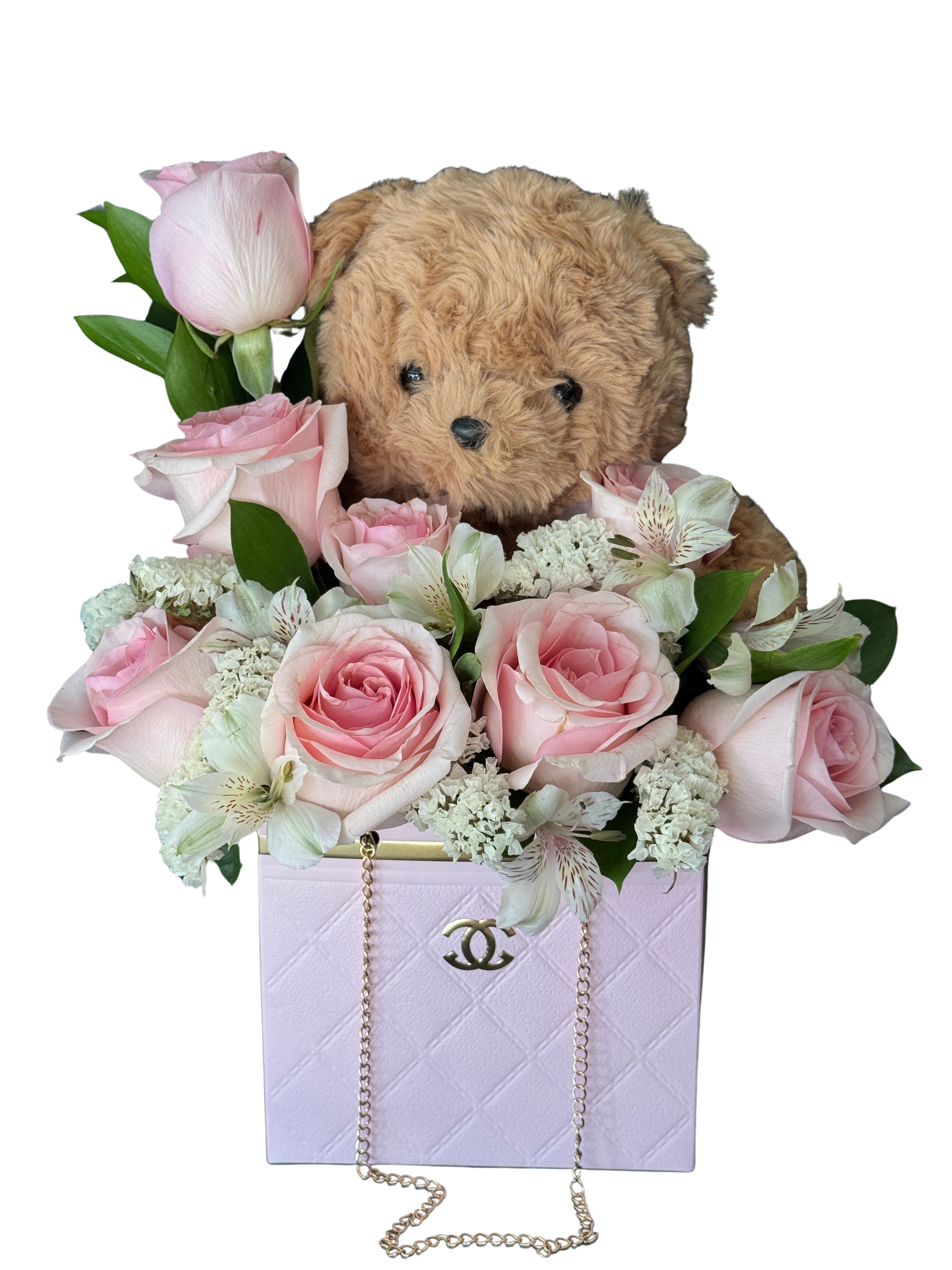 Pink roses and white flowers arranged around a teddy bear in a pink box