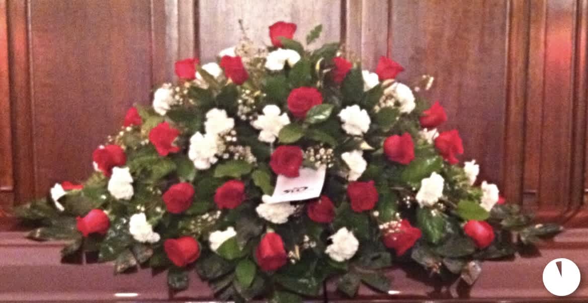 Large red and white rose arrangement on a casket