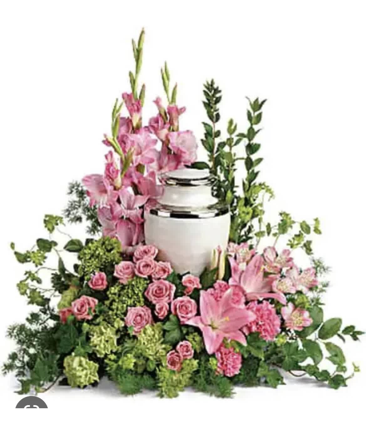 Pink flowers arranged around a white urn with greenery