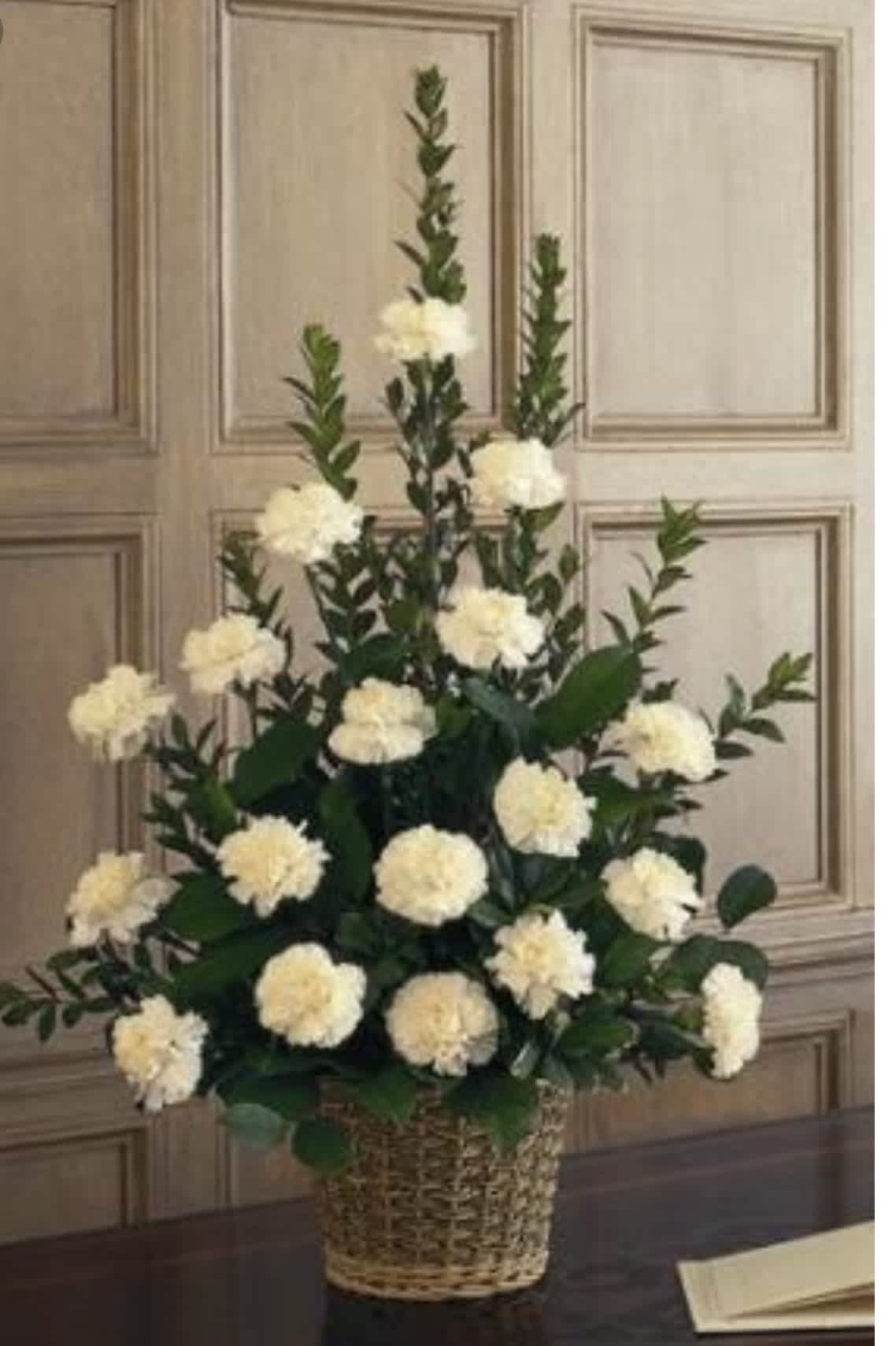 White pompom flowers arranged in a wicker basket