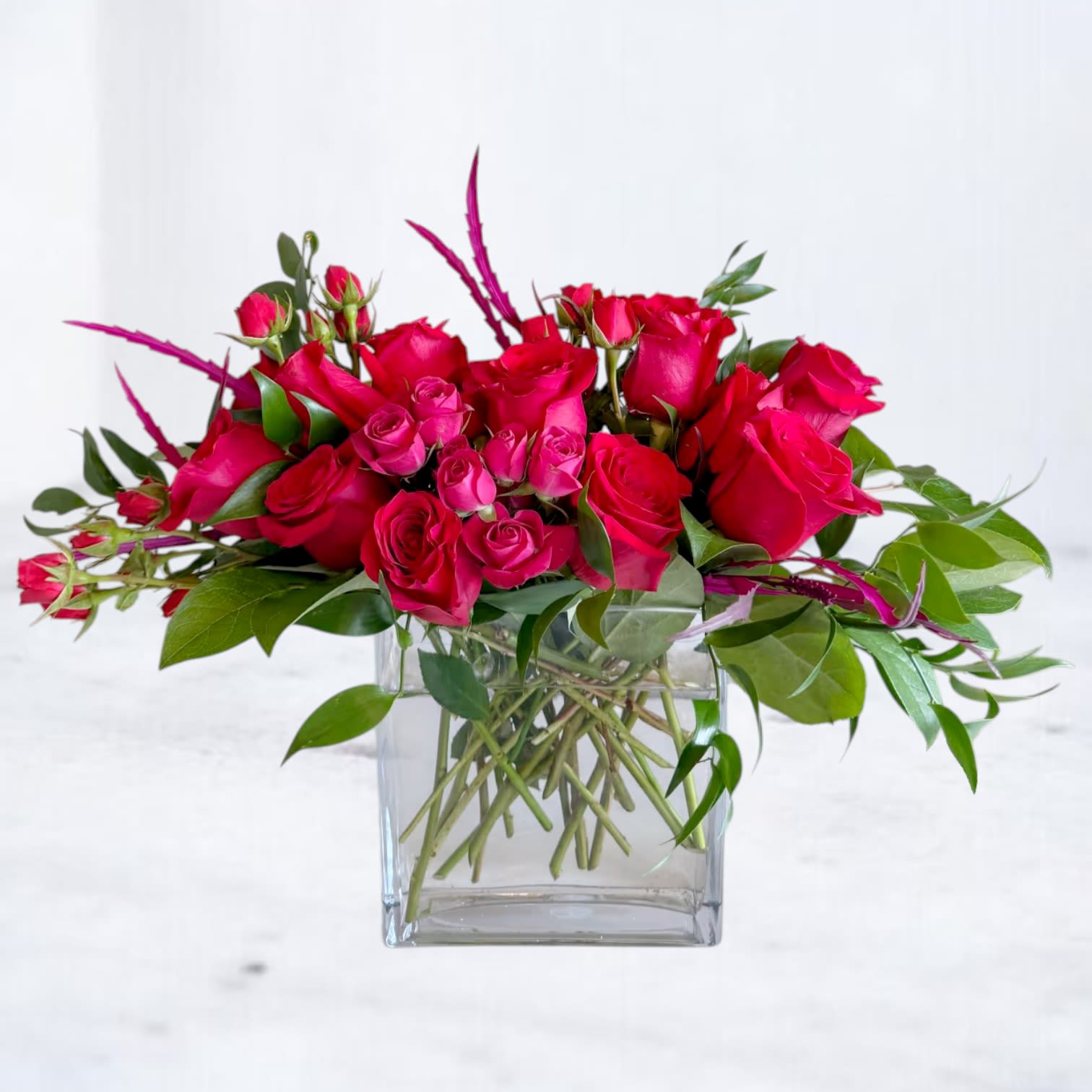 Pink rose bouquet in a clear square glass vase