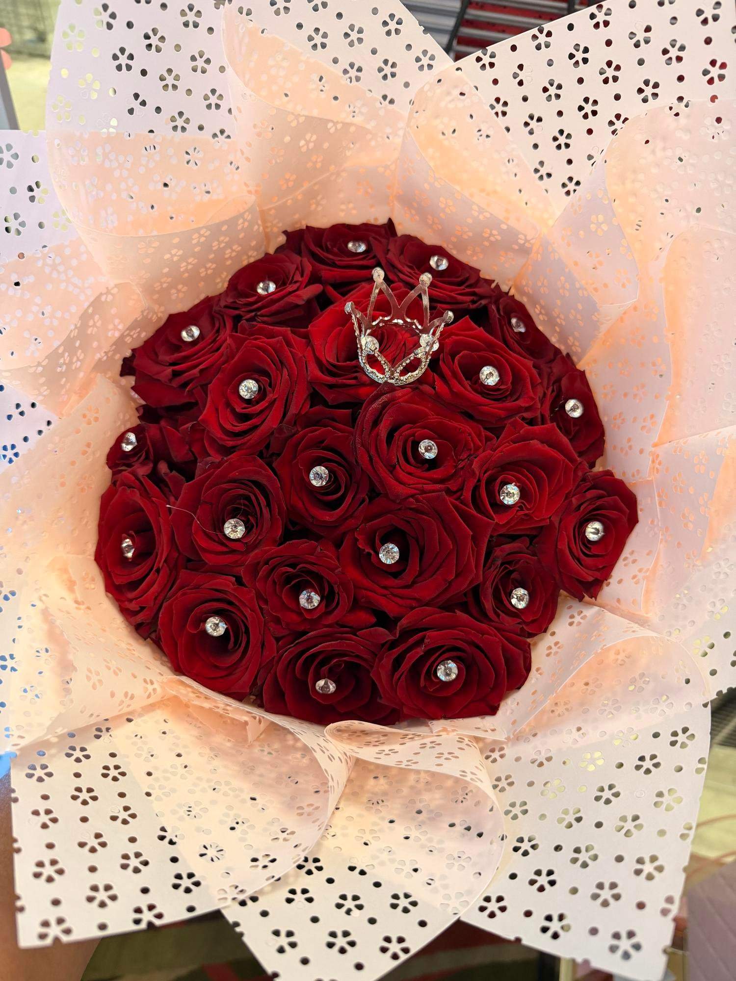 Bouquet of red roses wrapped in pale pink patterned paper