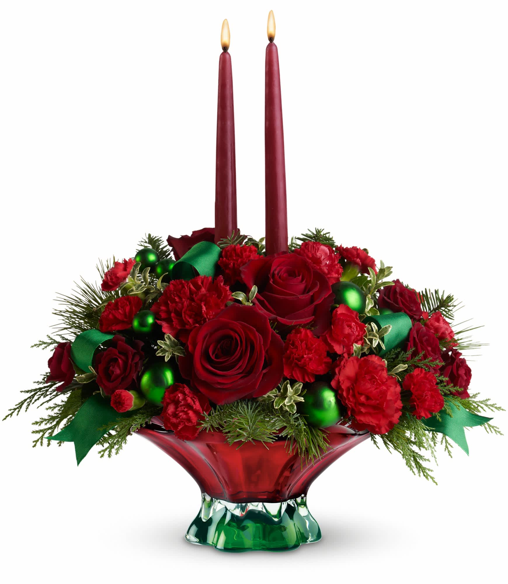 Teleflora's Joyful Christmas Centerpiece - It's looking a lot like one of the most beautiful Christmases ever with a magnificent centerpiece featuring festive flowers in an elegant hand-blown red and green glass bowl. Santa's elves really outdid themselves this time.    The radiant floral holiday centerpiece includes red roses, red spray roses, red carnations, miniature red carnations, cedar, noble fir, white pine and oregonia accented with green satin ribbon, green ornament balls and matte green ornament balls.    Approximately 17" W x 18 1/2" H    Orientation: All-Around    As Shown : T11X120A  Deluxe : T11X120B  Premium : T11X120C