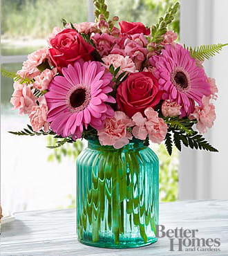 The FTD Gifts from the Garden Bouquet by Better Homes and Gardens - FTD proudly presents the Better Homes and Gardens Gifts from the Garden Bouquet. Blooming with beauty and a natural grace, your special recipient will find perfectly alluring, this mixed flower bouquet extends sweet sentiments and warm wishes. Hot pink roses and gerbera daisies take center stage in this flower arrangement surrounded by pink mini carnations, pink snapdragons, Boston Fern fronds and lush greens. Presented in an aqua blue glass vase with a vintage look they will adore, this stunning flower bouquet is set to make a wonderful impression in honor of a birthday, as a thank you or congratulations gift, or to just brighten and lighten their day. Approximately 14"H x 14"W.