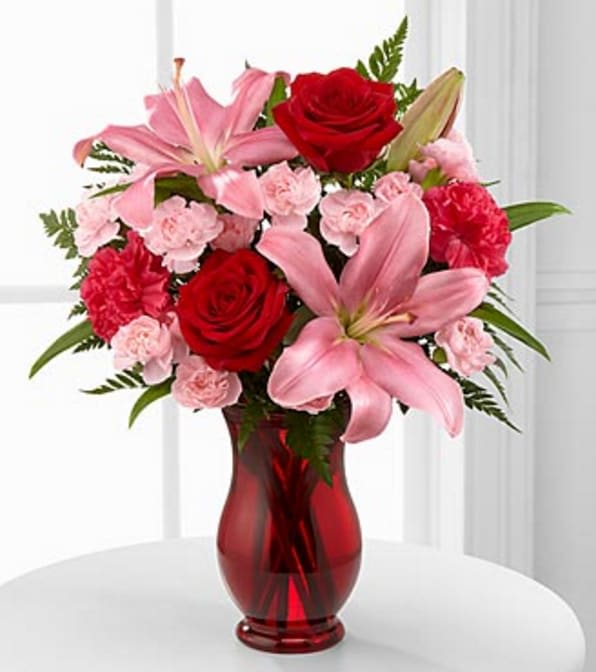 Hearts Emotions Bouquet- VASE INCLUDED - he Hearts Emotions Bouquet sends graceful blooms to your special someone, sweeping them off their feet with each blushing blossom! Gorgeous red roses, hot pink mini carnations, pink mini carnations, pink limonium, pink lilies, and lush greens are brought together to create a flower arrangement exuding the riches of romance. Presented with a designer ruby red glass vase tied with a pink satin ribbon at the neck, this exquisite mixed flower bouquet will convey your heart's every emotion. GOOD Bouquet includes 8 stems with vase. Approximately 16"H x 14"W. BETTER Bouquet includes 12 stems. Approximately 17"H x 15"W. Your purchase includes a complimentary personalized gift message.