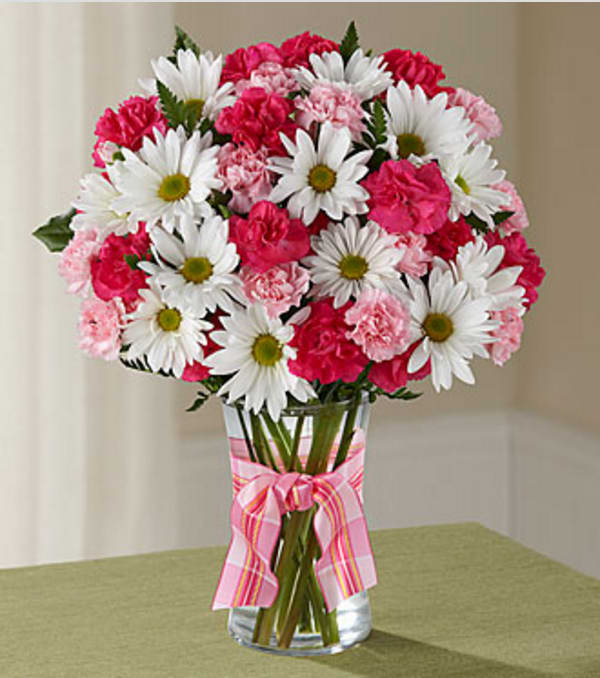 The Sweet Surprises® Bouquet by FTD® - VASE INCLUDED - Sending a Sweet Surprises® Bouquet by FTD® is an absolutely charming way to send your warmest sentiments. Hot pink mini carnations, pink mini carnations, white traditional daisies and lush greens are sweetly situated in a classic clear vase accented with a perfectly pink designer ribbon to create a bouquet that will delight your special recipient at every turn. GOOD bouquet is approximately 15"H x 12"W. BETTER bouquet is approximately 16"H x 13"W. BEST bouquet is approximately 16"H x 13"W. Your purchase includes a complimentary personalized gift message.