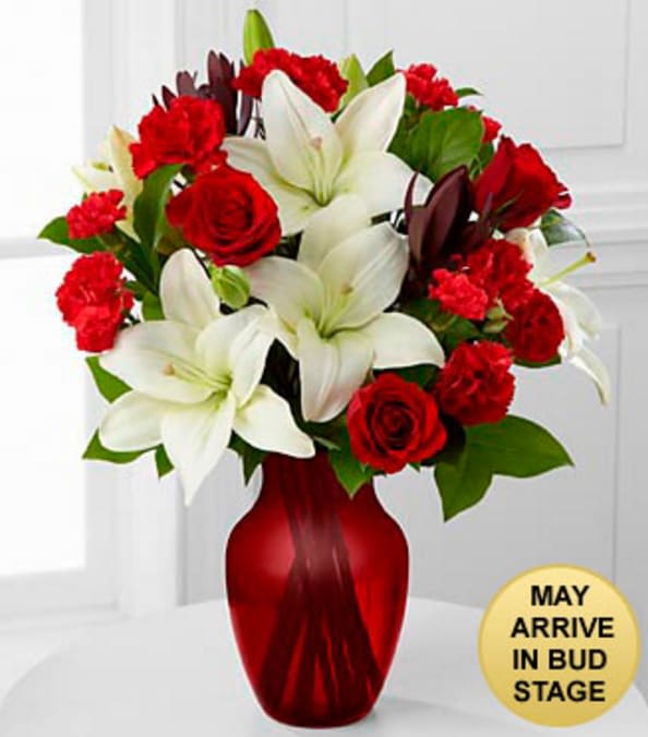 Hearts in Harmony Mixed Flower Bouquet - VASE INCLUDED - Picked fresh from the farm to offer your special recipient a gift blooming with romance and sweet affection, our stunning Hearts in Harmony Mixed Flower Bouquet is a classic romantic gesture that will melt their heart at every turn. Hand gathered in select floral farms and flaunting the eye-catching combination of red and white, this stunning flower arrangement has been picked fresh for you to help you celebrate a birthday, anniversary, or to convey your heart's true wish. This bouquet includes the following: red roses, white Asiatic Lilies, red carnations, red mini carnations, and an assortment of lush greens. Presented with a red glass vase.  GOOD bouquet is approximately 16"H x 12"W. BETTER bouquet is approximately 18"H x14"W. *May Arrive in Bud Stage. Your purchase includes a complimentary personalized gift message.