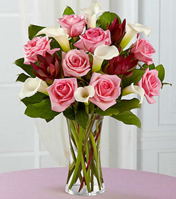 Fabled Beauty Bouquet - VASE INCLUDED - Picked fresh from the farm to delight your special recipient with its sweet sophistication, our Fabled Beauty Rose &amp; Mini Calla Lily Bouquet is blooming with gorgeous grace to celebrate all of life's most treasured moments. Hand gathered in select floral farms and showcasing the winning color combination of pink and white, this stunning flower arrangement has been picked fresh for you to help you celebrate a birthday, anniversary, or the birth of a new baby girl. This bouquet includes the following: pink roses, white mini calla lilies, and an assortment of lush greens. Available with a selection of vases to fit your gifting needs. GOOD bouquet includes 15 stems with clear glass vase. Approximately 16"H x 15"W. BETTER bouquet includes 19 stems with clear glass vase. Approximately 17"H x 15"W. Your purchase includes a complimentary personalized gift message.