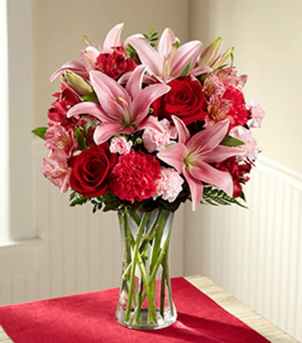 Forever Love Valentine's Day Bouquet - Vase INCLUDED - Picked fresh from the farm to bring the love and beauty of Valentine's Day straight to your special recipient's door, our Forever Love Valentine's Day Bouquet is that perfect picture gift you've been searching for. Hand gathered at select floral farms and bringing together an impressive array of blushing pink and red blooms, this unforgettable bouquet has been picked fresh for you to create a rush of romance in honor of this coming February 14th. Bouquet includes: pink Asiatic Lilies, red roses, pink Peruvian Lilies, red Peruvian Lilies, fuchsia carnations, pink mini carnations and lush greens. Available with or without a classic clear glass vase.  GOOD bouquet is approx. 18"H x 13"W. BETTER bouquet is approx. 19"H x 14"W. BEST bouquet is approx. 20"H x 16"W. Your purchase includes a complimentary personalized gift message.