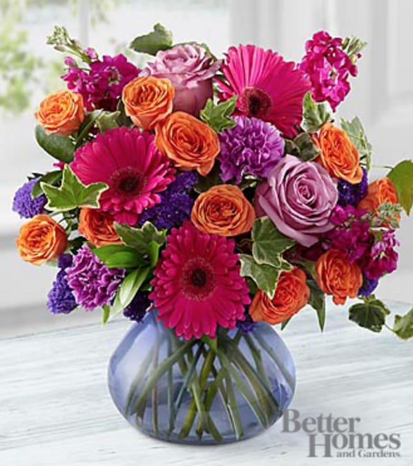 The FTD® Life in Bloom Bouquet by Better Homes and Gardens® - VASE INCLUDED - Picked fresh from the farm and bursting with a bright array of colors, the FTD® Life in Bloom Bouquet by Better Homes and Gardens® is a true marvel. Hand gathered in select floral farms and showcasing the brilliant vibrant colors of fuchsia, lavender, orange and purple, this fresh flower arrangement has been picked fresh for you to help celebrate a birthday, send your get well wishes, or to express your heartfelt thanks and gratitude. This bouquet includes the following: lavender roses, fuchsia stock, orange spray roses, lavender carnations, fuchsia mini gerbera daisies, purple statice, and an assortment of lush greens with a purple glass vase. GOOD bouquet includes 15 stems with vase &amp; approximately 14"H x 13"W. BETTER bouquet includes 19 stems with vase &amp; approximately 14"H x 14"W. BEST bouquet includes 24 stems with vase &amp; approximately 15"H x 15"W. Your purchase includes a complimentary personalized gift message.