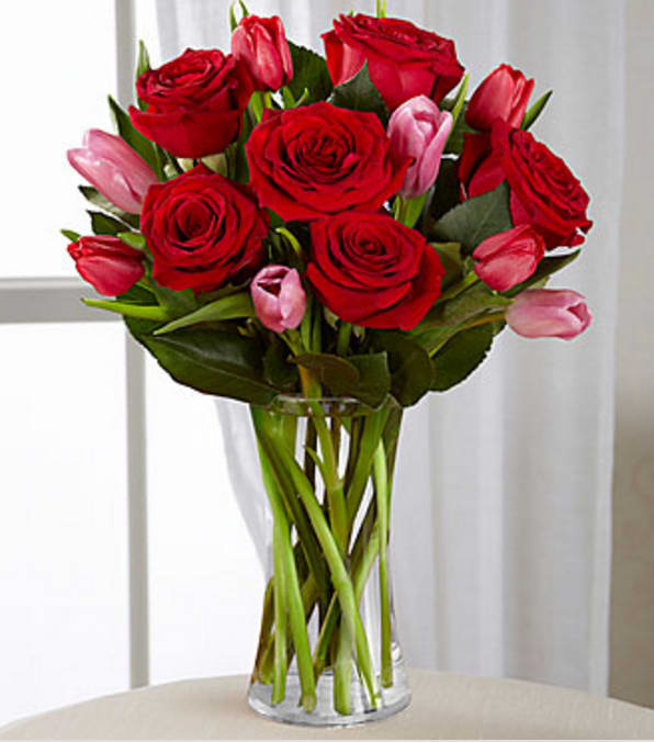 Let Love In Valentine Bouquet - VASE INCLUDED - The Let Love In Valentine Bouquet speaks of romantic moments through rich color and dazzliing blooms. Our finest red roses mingle with bright red and popping pink tulips to create the perfect way to win their heart this coming Valentine's Day.  Good Bouquet - Approximately 15"H x 12"W. Better Bouquet - Approximately 16"H x 13"W. Best Bouquet - Approximately 17"H x 14"W. Your purchase includes a complimentary personalized gift message.