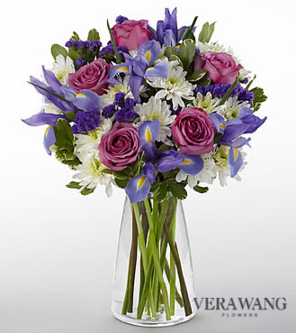 Vera Wang Sweet Sophistication Bouquet - VASE INCLUDED - The Vera Wang Sweet Sophistication Bouquet has been picked fresh from the farm to impress your special recipient at every turn. Exhibiting a soft elegance and grace synonymous with Vera Wang's style and aesthetic, this flower arrangement has been picked fresh for you and hand gathered at select floral farms to create a simply stunning anniversary, birthday or congratulations gift. This bouquet includes the following: lavender roses, blue iris, white traditional daisies, purple statice and lush greens. This arrangement includes 15 stems with a superior crystal glass vase. Approximately 19"H x 16"W. Your purchase includes a complimentary personalized gift message.