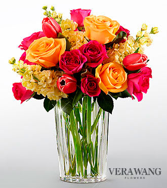The FTD® Beauty and Grace™ Bouquet by Vera Wang - VW9S  FTD® proudly presents the Beauty and Grace™ Bouquet by Vera Wang. Displaying a refreshing sense of color and sunlit sophistication, this bouquet of fuchsia tulips, peach roses, pale yellow stock and hot pink spray roses are presented in a modern clear glass vase to delight your special recipient with its eye-catching demeanor.