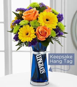 The FTD® Congrats Bouquet - TCGS   The FTD® Congrats Bouquet is set to offer your congratulations wishes to your special recipient with bright blooming beauty! Vibrant orange roses and yellow gerbera daisies are surrounded by purple statice, green button poms, and lush greens to create an unforgettable flower arrangement. Presented in a designer blue glass vase with a silver metallic decorative tag stating, "Congrats," dangling from the neck, this mixed flower bouquet will be the perfect gift to send in honor of a graduation, the birth of a new baby boy, a new job or promotion, or any of life's special moments. GOOD bouquet is approximately 14"H x 10"W.