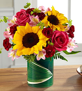The FTD® Fresh Outlooks™ Bouquet - LF2S  When the occasion calls for a joyful burst of sunshine, this thrilling mixed bouquet is all ready to chase any trace of a cloudy day away. Big, happy sunflowers set the tone and "pop" beautifully among contrasting pink roses and alstroemeria along with burgundy mini-carnations arranged in a ceramic "illusion" vase that convincingly replicates the look of a leaf-lined glass pillar. It's an arrangement guaranteed to deliver a fresh outlook for making any day, extra special. GOOD bouquet is approximately 11"H x 11"W. 