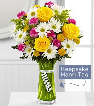 The FTD® Thanks Bouquet - TTYS  The FTD® Thanks Bouquet is a simply gorgeous way to send your gratitude and thanks to friends, family, and loved ones near and far! Bright yellow roses are surrounded by white traditional daisies, hot pink mini carnations, yellow button poms and lush greens to create an impressive flower arrangement. Presented in a designer green glass vase with a silver metallic decorative tag stating, "Thanks," dangling from the neck, this mixed flower bouquet is a wonderful gift to send as a thank you to any of the deserving people in your life.