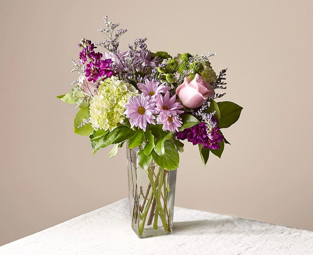 Lavender Bliss - Pretty in purple! Our Lavender Bliss™ Bouquet is an enchanting take on a classic refined color, with accents of ivory and green. This sweet arrangement is crafted with hydrangea, roses and alstroemeria to delight your loved ones!