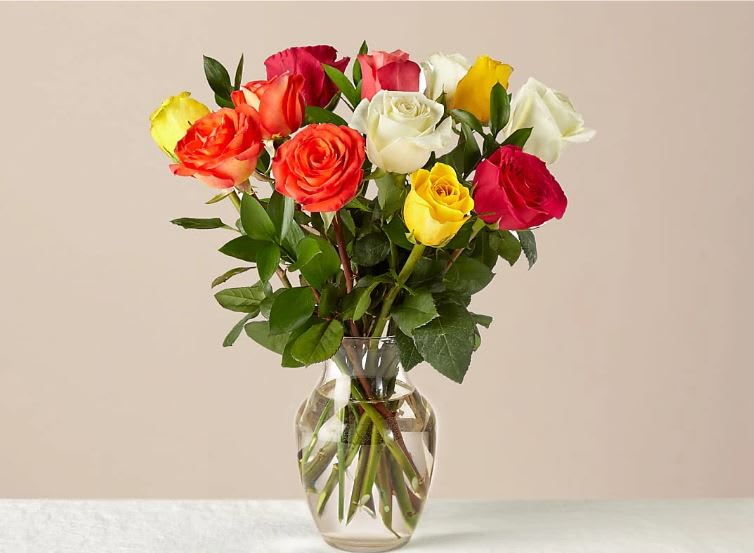 Mixed Roses - Colorful and blooming, this vibrant bouquet of a dozen roses is an instant mood booster. An abundance of the freshest roses is paired with touches of lush greenery to delight everyone from your special someone to your best friend for any occasion or sentiment.  One dozen mixed roses are about 17"H by 15"W