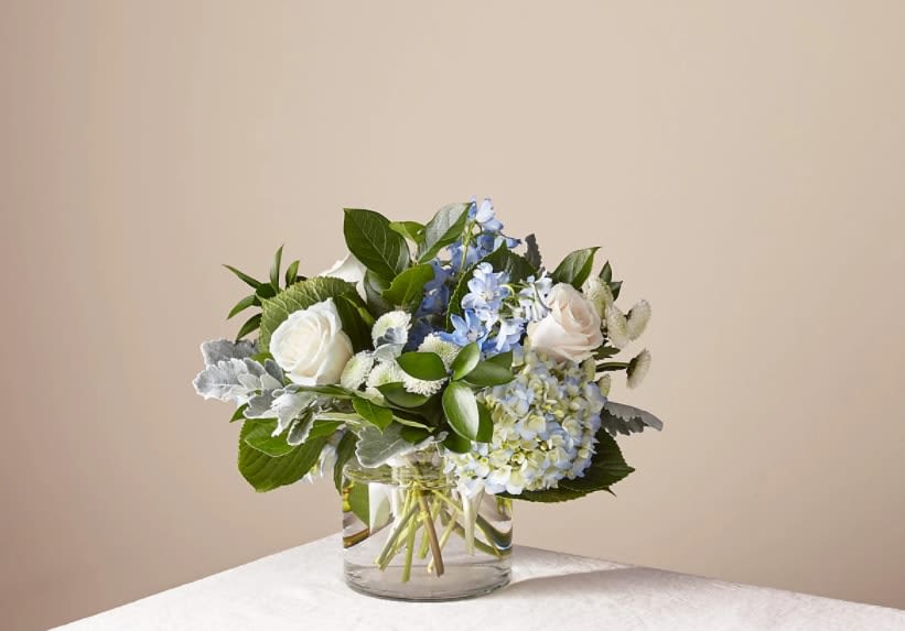 Clear Skies Bouquet - Let this uplifting arrangement be reminders of the clear skies ahead. Capturing the feeling of hope that a new day brings, this bouquet is composed of voluminous hydrangea blooms and vibrant belladonna delphinium to refresh their mood.