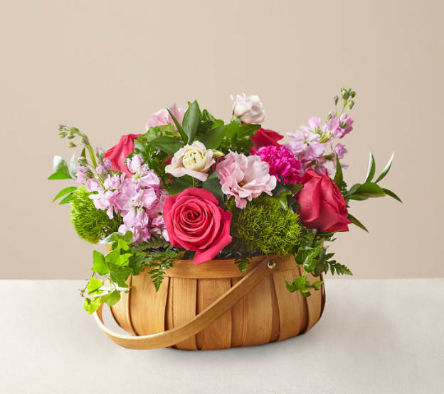 Radiance in Bloom Basket - Inspired by bright shades and soft textures, this arrangement will wow your loved ones with its mix of roses, carnations, and lisianthus in a woven basket.  The Original Bouquet is approximately 11"H x 16"W. 