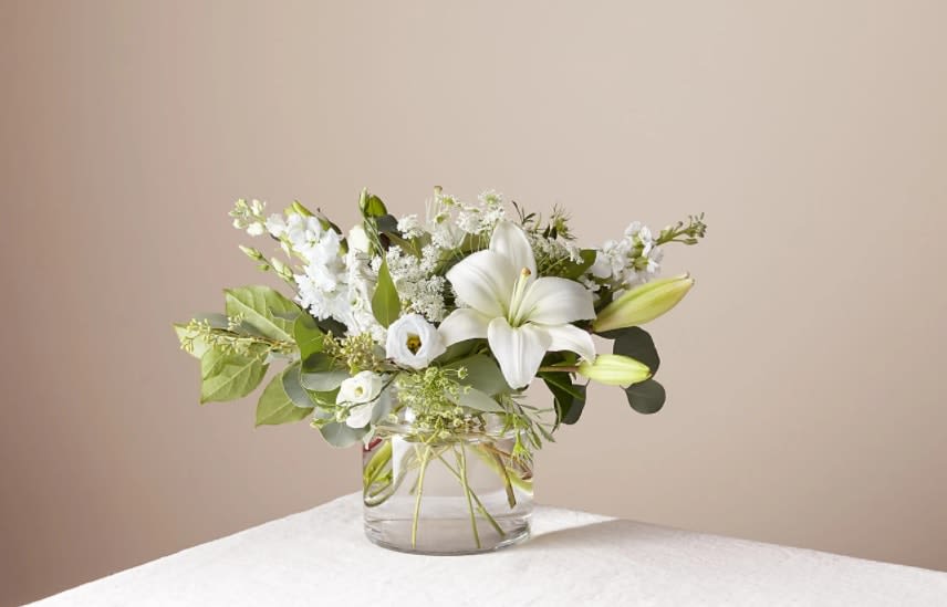Alluring Elegance Bouquet - An illuminating array of florals brings an air of elegance to any room it's placed. This arrangement features refined florals like lilies, Queen Anne's Lace and Veronica in a clear glass vase to add a touch of sophisticated style to your special occasions.  The Original Bouquet is approximately 14"H x 16"W.