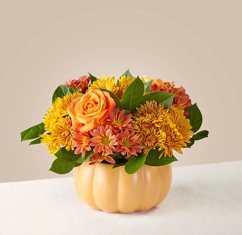 Pumpkin Spice Forever Bouquet - Why wait to indulge in your favorite fall flavors once a year? Let the Pumpkin Spice Forever bouquet bring a delicious touch of fun to your space. The warmed–tone roses and accented pompon stems are better admired around a dinner table.  The Original Bouquet is about 9"H x 13"W.